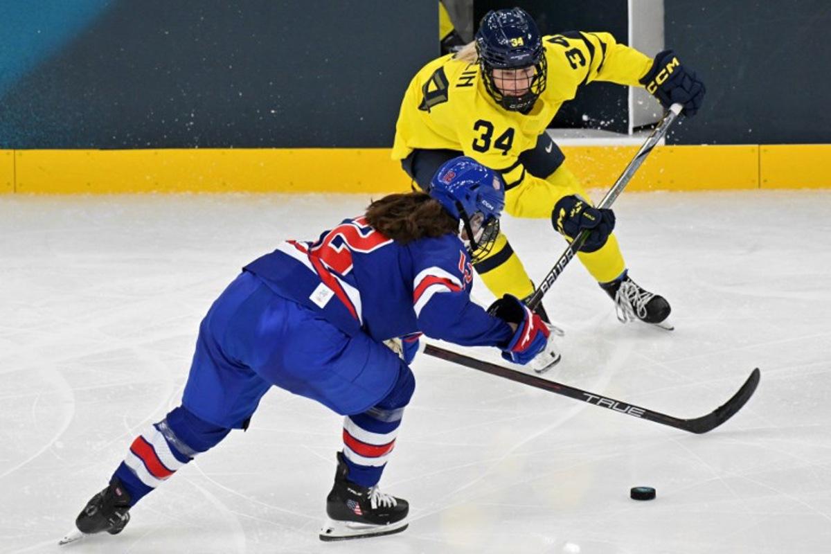 USA's forward #12 Kelly Pannek (front) fights for the puck with Sweden's #34 Mira Hallin during the women's play-off semi-final ice hockey match between USA and Sweden at the Milano Santagiulia Ice Hockey Arena during the Milano Cortina 2026 Winter Olympic Games in Milan, on February 16, 2026. Alexander NEMENOV / AFP