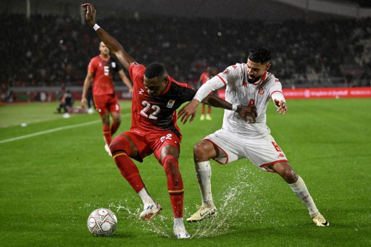 Uganda's forward #22 Jude Ssemugabi and Tunisia's forward #08 Elias Saad vie during the Africa Cup of Nations (CAN) Group C football match between Tunisia and Uganda at Rabat Olympic Stadium in Rabat on December 23, 2025. SEBASTIEN BOZON / AFP