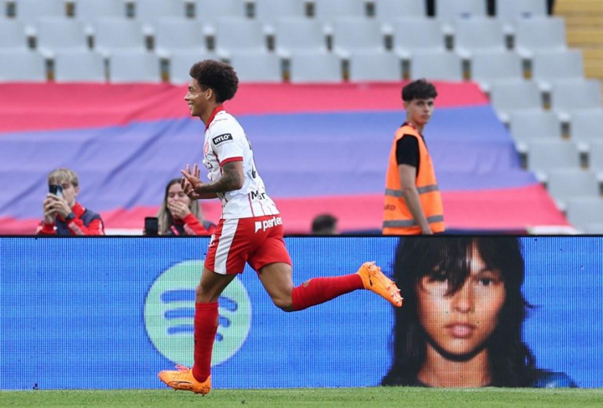Girona's Belgian defender #20 Axel Witsel celebrates scoring his team's first goal with teammates during the Spanish league football match between FC Barcelona and Girona FC at Estadi Olimpic Lluis Companys in Barcelona on October 18, 2025. Josep LAGO / AFP