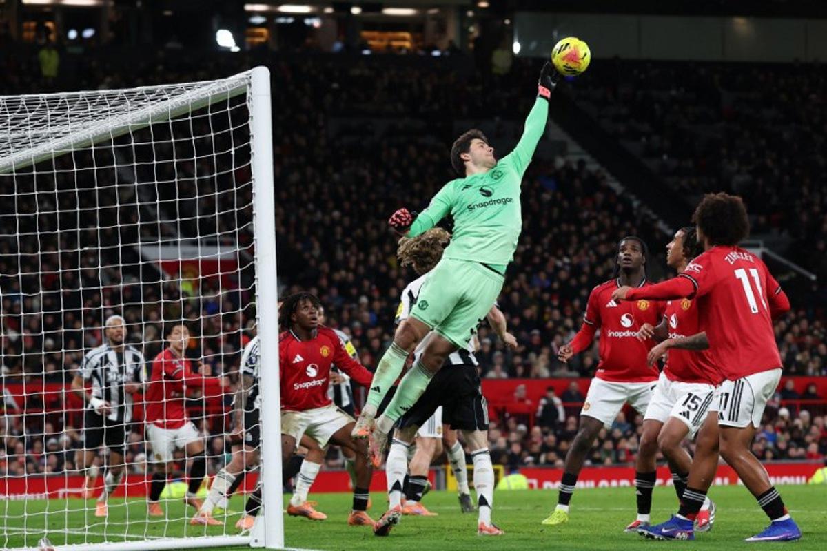 Manchester United's Belgian goalkeeper #31 Senne Lammens fails to push the ball away but is fouled during the English Premier League football match between Manchester United and Newcastle United at Old Trafford in Manchester, north west England, on December 26, 2025. Darren Staples / AFP