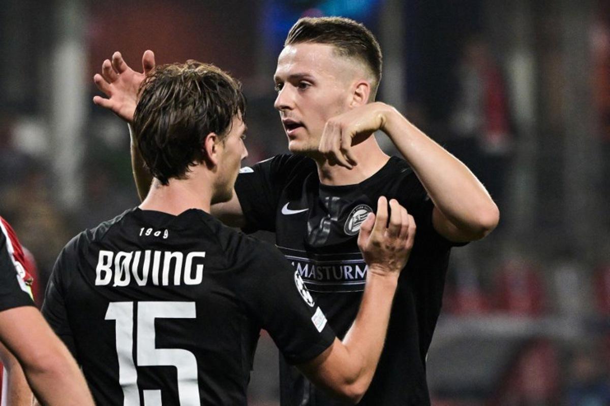 Sturm Graz's Danish forward #15 William Boving and Sturm Graz's Belgian defender #24 Dimitri Lavalee celebrate after Brest's scored an own goal during the UEFA Champions League 1st round day 1 football match between Stade Brestois 29 (Brest) and Sturm Graz, at the Roudourou Stadium in Guingamp, western France, on September 19, 2024. Damien MEYER / AFP