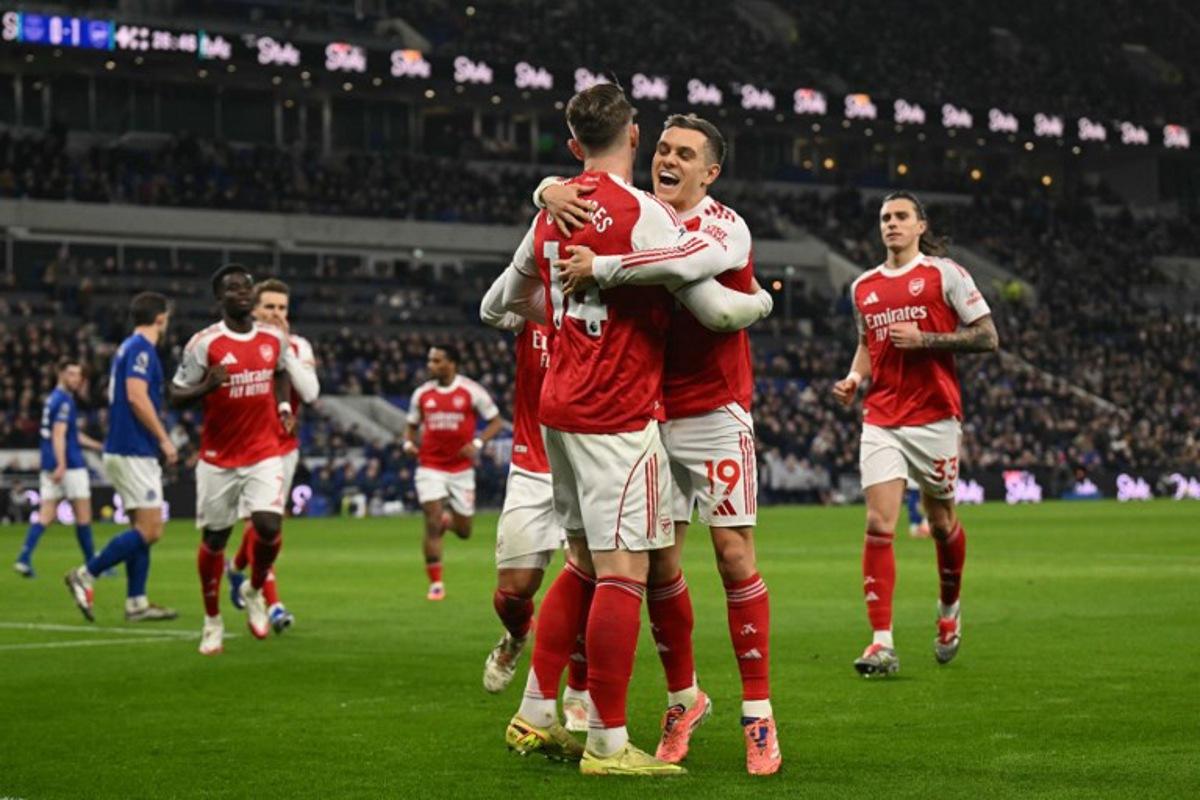Arsenal's Belgian midfielder #19 Leandro Trossard (R) embraces Arsenal's Swedish striker #14 Viktor Gyokeres (L) as Gyokeres celebrates scoring the opening goal to take the lead 0-1 during the English Premier League football match between Everton and Arsenal at Hill Dickinson Stadium in Liverpool, north west England on December 20, 2025. Oli SCARFF / AFP