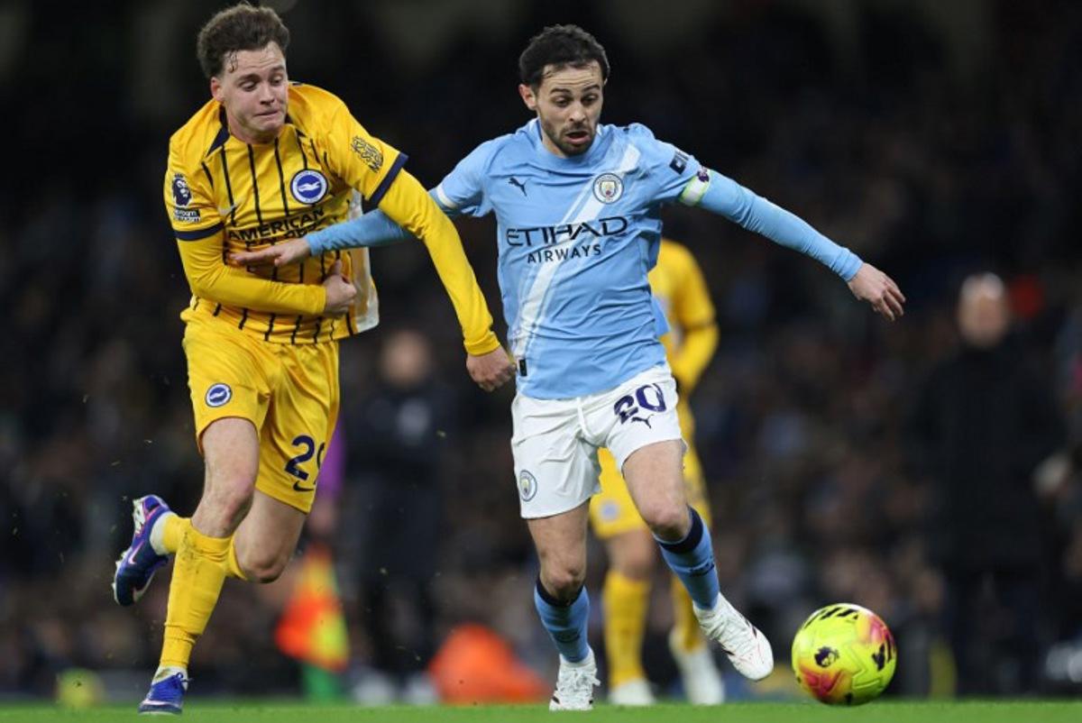 Manchester City's Portuguese midfielder #20 Bernardo Silva (R) takes on Brighton's Belgian defender #29 Maxim De Cuyper (L) during the English Premier League football match between Manchester City and Brighton and Hove Albion at the Etihad Stadium in Manchester, north west England, on January 7, 2026. Darren Staples / AFP