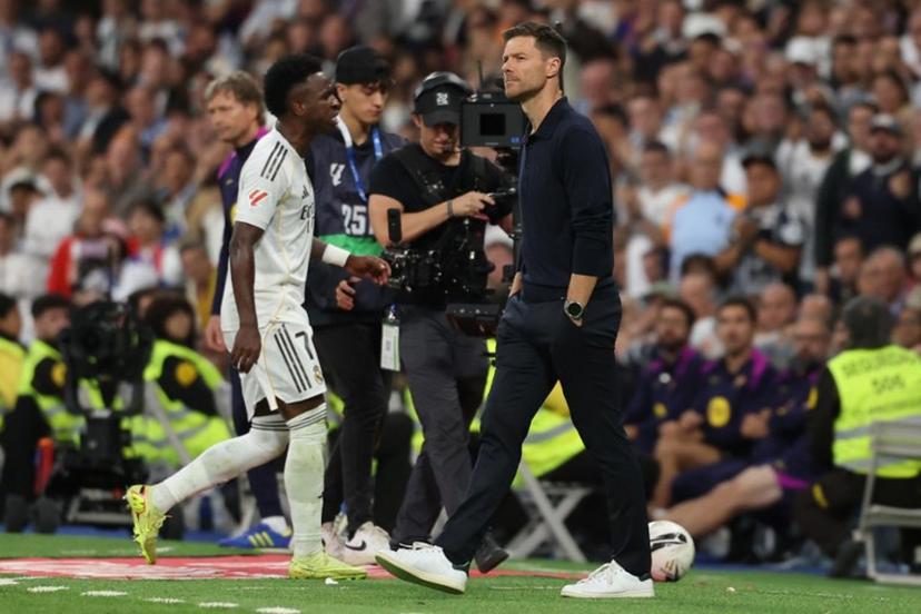 Real Madrid's Brazilian forward #07 Vinicius Junior walks past Real Madrid's Spanish coach Xabi Alonso as he is substituted during the Spanish league football match between Real Madrid CF and FC Barcelona at Santiago Bernabeu Stadium in Madrid on October 26 , 2025.  Oscar DEL POZO / AFP