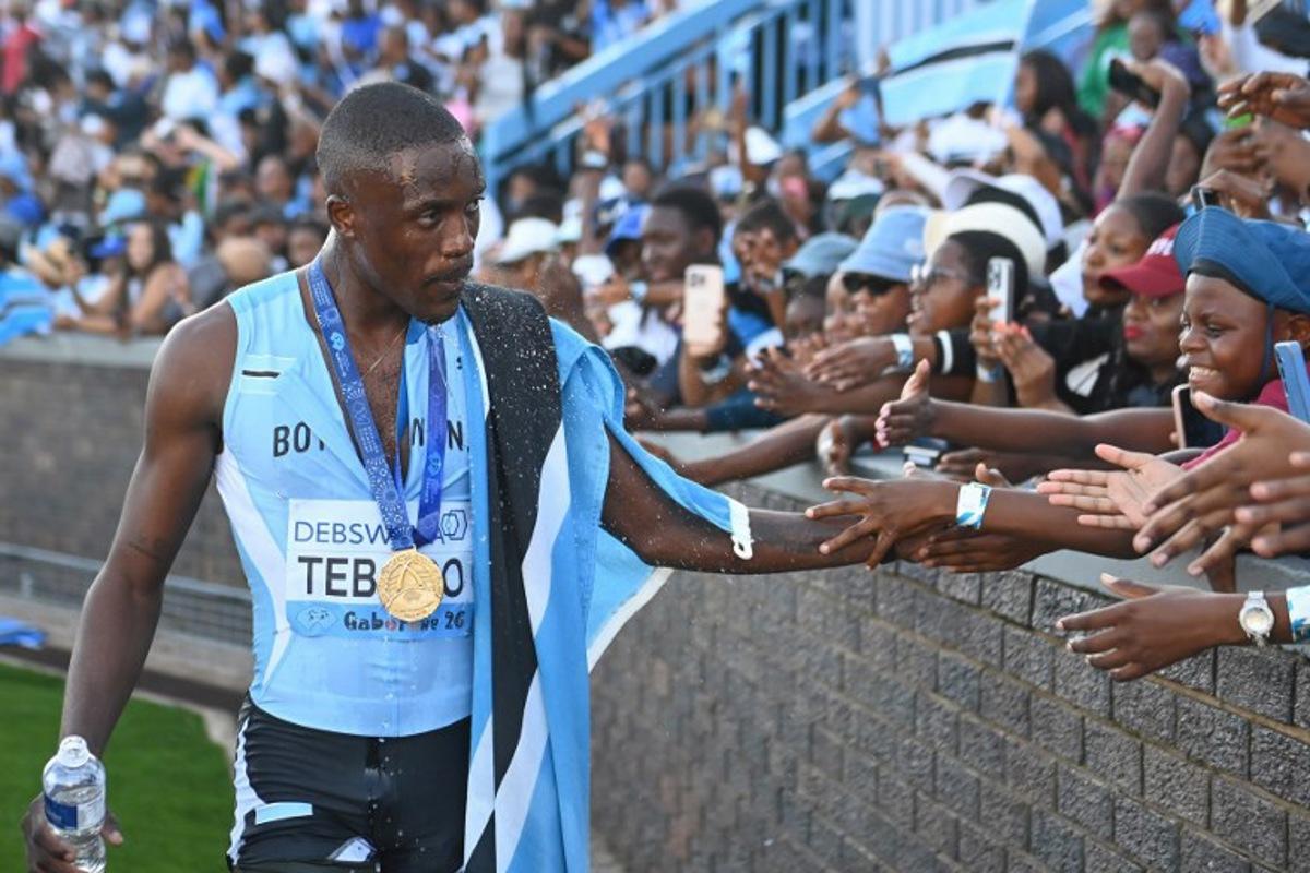 Botswana's Letsile Tebogo celebrates with fans after winning the men's 4x400m relay final during the Gaborone 26 World Athletics Relays at the National Stadium in Gaborone on May 3, 2026. AFP