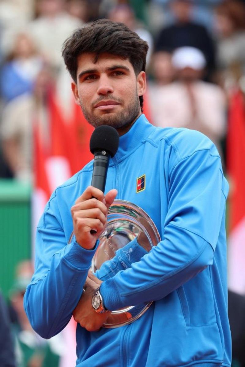 Spain's Carlos Alcaraz delivers a speech as he celebrates second place on the podium after the Monte Carlo ATP Masters Series Tournament final tennis match against Italy's Jannik Sinner on Court Rainier III at the Monte-Carlo Country Club in Roquebrune-Cap-Martin, south-eastern France on April 12, 2026. Valery HACHE / AFP