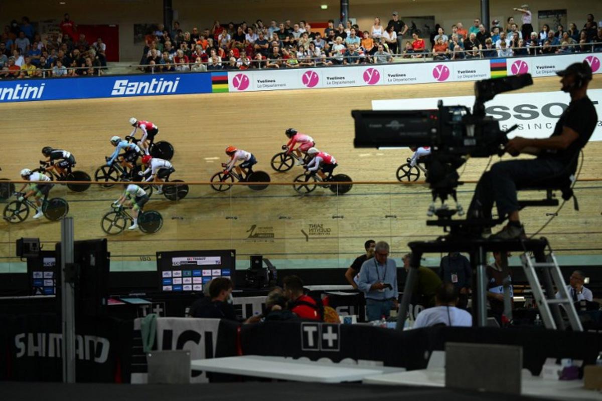 A camera operator films as cyclists compete in the Women's Madison 30km final during the UCI Track Cycling World Championships at the Velodrome of Saint-Quentin-en-Yvelines, southwest of Paris, on October 15, 2022. Anne-Christine POUJOULAT / AFP