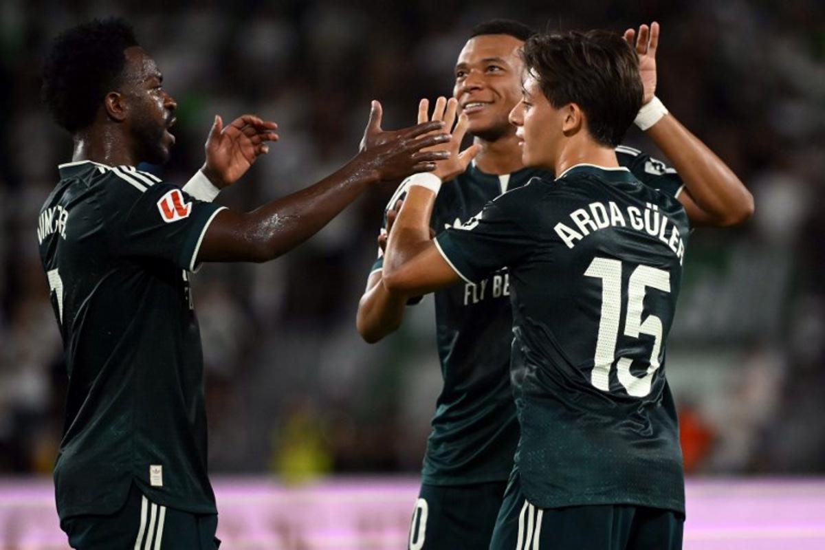 Real Madrid's Turkish midfielder #15 Arda Guler celebrates scoring the opening goal with Real Madrid's French forward #10 Kylian Mbappe next to Real Madrid's Brazilian forward #07 Vinicius Junior (L) during the Spanish league football match between Elche CF and Real Madrid CF at Martinez Valero Stadium in Elche on September 15, 2026. JOSE JORDAN / AFP
